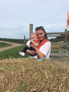Mom and son in front of a hay bale